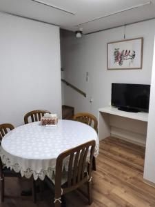 大阪Guesthouse Atelier Ten 民泊アトリエ天的一间有白色桌子和椅子的餐厅