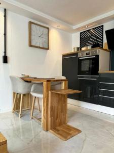 a kitchen with a table and a clock on the wall at Little Lukass in Ulm +6 photos