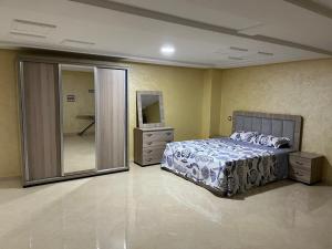 a bedroom with a bed and a large mirror at New complex in Nador