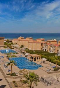 a resort with a large swimming pool next to the ocean at Selena Bay Luxury Sea View 1BR Apartment, Private Beach and Pool in Hurghada
