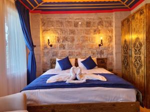 a bedroom with a bed with towels on it at Elite Rose Cappadocia in Uçhisar
