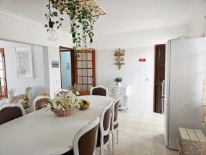 a kitchen and dining room with a white table and chairs at Sunshine, casa de campo e praia, estilo e conforto, espaço e privacidade, perfeita para as suas férias em Olhão in Moncarapacho