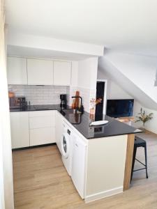 a kitchen with white cabinets and a washer and dryer at Casa rural El Rincón de la Yedra in Setenil +20 photos