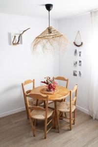a dining room table with chairs and a chandelier at Casa rural El Rincón de la Yedra in Setenil