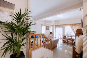 a woman sitting in a living room with a plant at Lala Luxury House in Argos