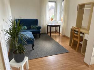 a living room with a blue couch and a table at Gästehaus-Schild in Dormagen