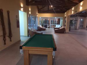 a pool table in the middle of a room with couches at Apto PDI na praia em Baixio in Baixio