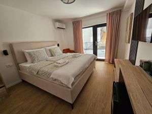 a bedroom with a bed and a large window at Lendas Apartments & Rooms in Baška Voda