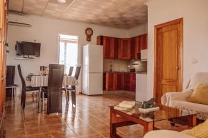 a kitchen and living room with a table and a refrigerator at Casa Rural Entreolivos in Baena
