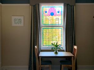 a dining room table with a stained glass window at Avon Terrace Guest House in York