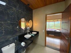a bathroom with two sinks and a bath tub at Chalé Pedra Ferro-Recanto Venâncio in São Bento do Sapucaí