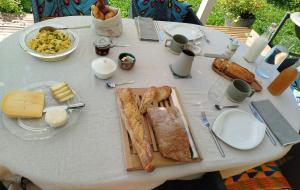 a white table with bread and cheese on it at Grange du lac in Meillerie