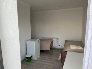 Tamchy"Bilim" Guest House的小房间设有两张床和一台冰箱