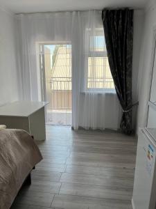 Tamchy"Bilim" Guest House的一间带床和大窗户的卧室