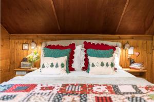 a bedroom with a bed with red and green pillows at Le Petit Rêve - Lac de Montriond in Montriond