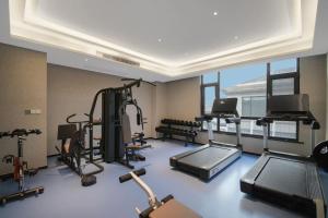 une salle de sport avec plusieurs tapis de course et vélos d'exercice dans l'établissement Mehood Hotel, Changzhou Jintan Babaiban, à Jintan