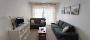 a living room with a couch and a tv at O fogar de Sara in O Grove