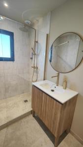 un bagno con lavandino e doccia con specchio di L'appart Lila - Jacuzzi vue mer a Lacanau Altre 20 foto