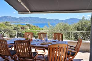 a dining table with chairs and a view of the ocean at Résidence Capicciolo Villa A CIGALA in Olmeto