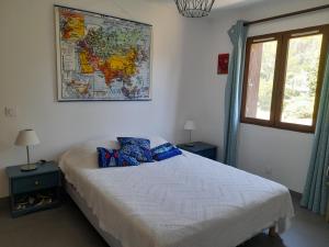 een slaapkamer met een bed met een kaart aan de muur bij Grande terrasse et vue sur le site antique in Vaison-la-Romaine
