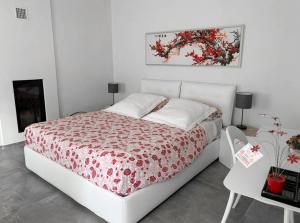 a bedroom with a bed with a red and white bedspread at Horse Shoe House in Chiaverano