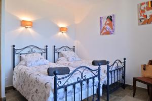 two beds in a bedroom with white walls at Résidence Capicciolo Villa A CIGALA in Olmeto