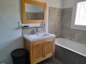 een badkamer met een wastafel en een ligbad bij Grande terrasse et vue sur le site antique in Vaison-la-Romaine