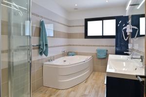 a bathroom with a tub and two sinks and a shower at Résidence Capicciolo Villa A CIGALA in Olmeto +6 photos