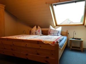 1 dormitorio con cama de madera y ventana en Ferienwohnung Tammen, en Westoverledingen 12 fotos más
