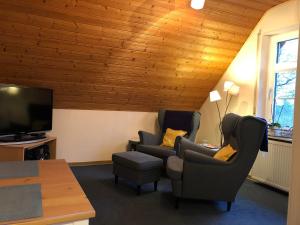 Una sala de estar con dos sillas y un televisor de pantalla plana. en Ferienwohnung Tammen, en Westoverledingen