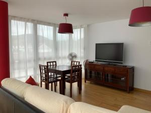 a living room with a television and a table and chairs at Piso los Rosales in Sarón