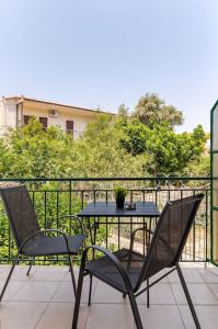 a table and two chairs on a balcony at Seaside Escape Apartments - Poseidon in Palaia Fokaia