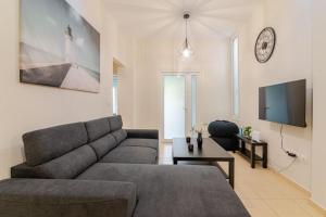 a living room with a couch and a tv at Seaside Escape Apartments - Poseidon in Palaia Fokaia