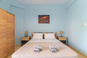 a bedroom with a bed with two pillows on it at Seaside Escape Apartments - Poseidon in Palaia Fokaia