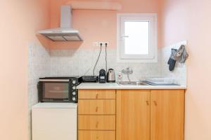 a small kitchen with a sink and a microwave at Seaside Escape Apartments - Poseidon in Palaia Fokaia