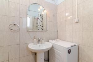 a white bathroom with a sink and a mirror at Seaside Escape Apartments - Poseidon in Palaia Fokaia +22 photos