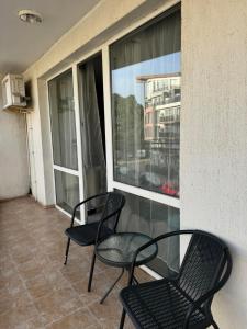 three chairs sitting on a balcony with a window at Студио Мая in Sunny Beach +3 photos