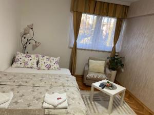 a small bedroom with two beds and a table at Stan na dan Siniša 2 in Valjevo