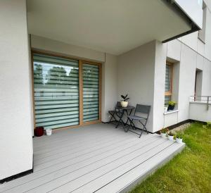 a deck with a table and chairs on a house at Oaza Przystań in Giżycko +1 photo