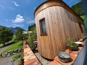 a wooden cylindrical building with a fence around it at UlMi's Tiny Haus in Dalaas