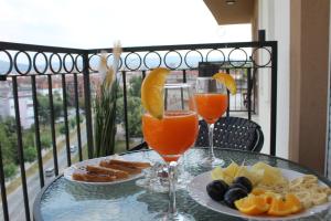 a table with two glasses of orange juice and snacks at Zara Lux Panorama in Kragujevac
