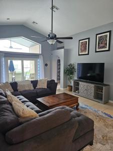 ein Wohnzimmer mit Couch und Flachbildfernseher in der Unterkunft Minnie Heaven in Kissimmee