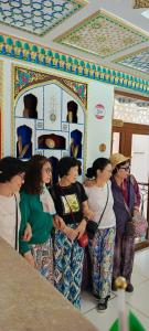 un groupe de femmes debout dans une pièce dans l'établissement Hotel Ansi Boutique W&S terrace, à Boukhara