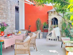 a patio with a table and chairs and a red wall at House Rinomeri in Lokva Rogoznica