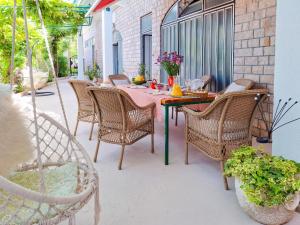 a patio with a table with wicker chairs at House Rinomeri in Lokva Rogoznica