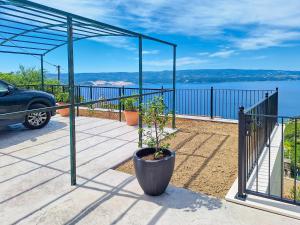 a potted plant on a patio with a view of the water at House Rinomeri in Lokva Rogoznica