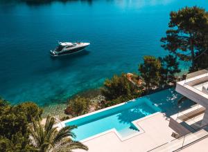 a boat in the water next to a swimming pool at Villa Mila in Selca