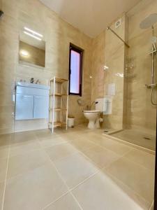 a bathroom with a shower and a toilet and a sink at Majestic Villas Pomorie Park in Sarafovo