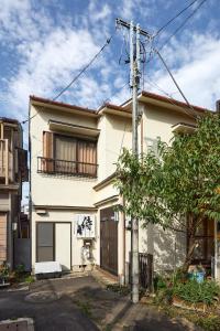 小田原市サムライハウス的带阳台和杆子的白色房屋