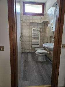 łazienka z toaletą, umywalką i oknem w obiekcie Villa a schiera raffinata con giardino w Lignano Sabbiadoro